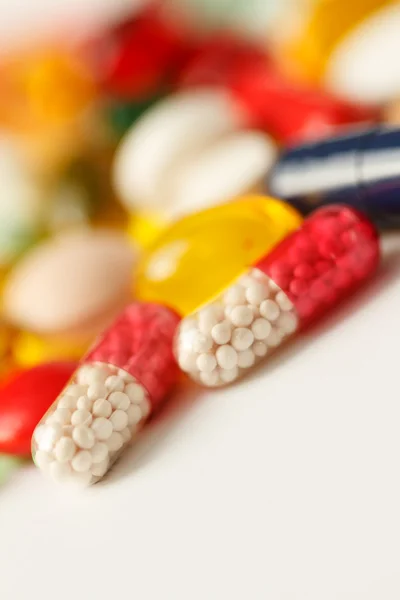 Pillole, compresse e capsule colorate su sfondo bianco — Foto Stock