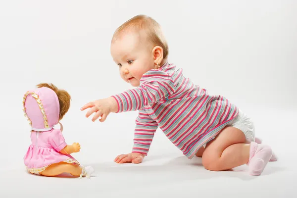 Baby girl playing with doll — Stock Photo, Image