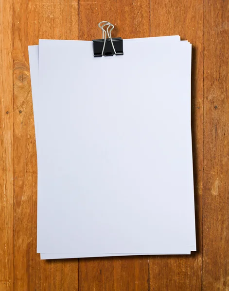 Black clip and White blank note paper hang on wood pane — Stock Photo, Image