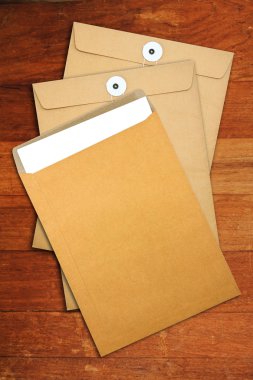 ahşap masa üzerinde kahverengi zarf belgesi