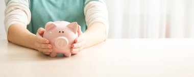 Kadın, para biriktirmek ve finansal konsept için domuzcuğa para yatırıyor.