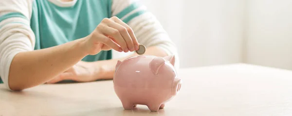 Mão mulher colocando dinheiro moeda em porquinho para economizar dinheiro riqueza e conceito financeiro — Fotografia de Stock