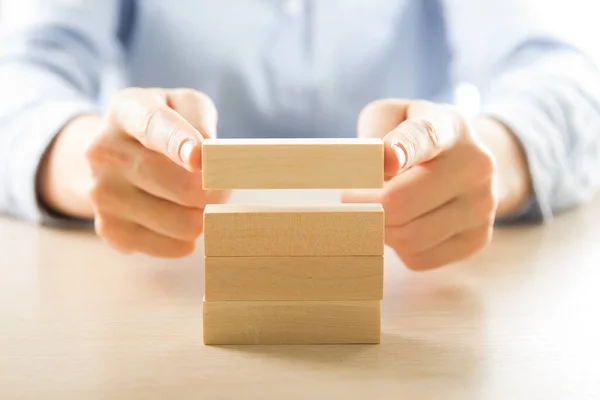 План і стратегія в бізнесі, ризик для розвитку бізнесу концепція з дерев'яними блоками, рука людини збирає і складає дерев'яний блок . — стокове фото
