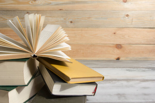 Open book, hardback books on wooden table. Back to school. Copy space.