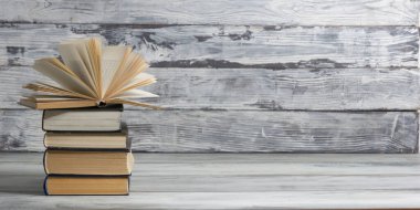 Açık kitap, ahşap masadaki ciltli kitaplar. Okula dönelim. Boşluğu kopyala.