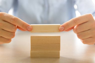 İş dünyasında plan ve strateji, İş Büyütme Riski Ahşap bloklar ile İş Büyüme Konsepti, insan eli yığılır ve ahşap bir blok istifleme