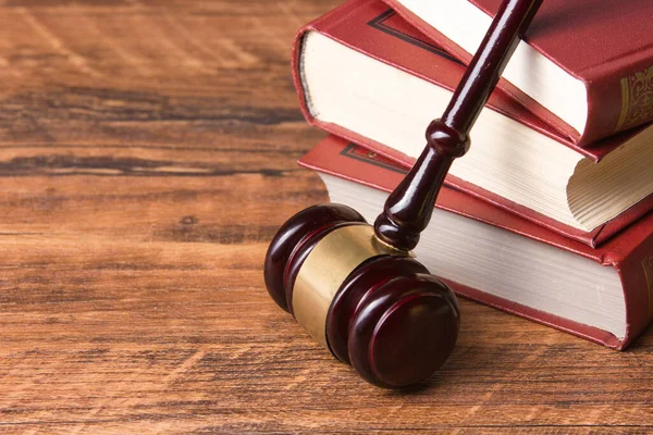 Law concept - Open law book with a wooden judges gavel on table in a courtroom or law enforcement office isolated on white background. Copy space for text