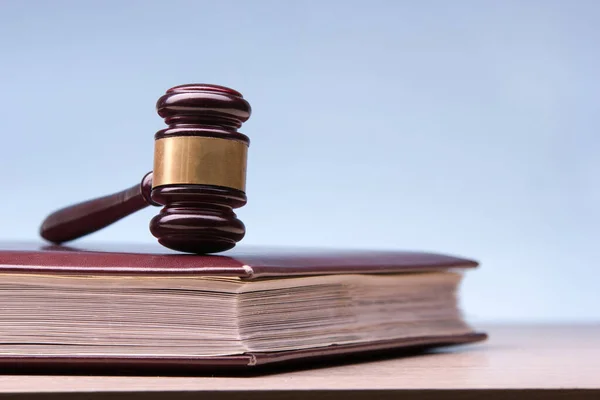 Law concept - Open law book with a wooden judges gavel on table in a courtroom or law enforcement office isolated on white background. Copy space for text