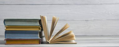 Açık kitap, ahşap masadaki ciltli kitaplar. Okula dönelim. Boşluğu kopyala.