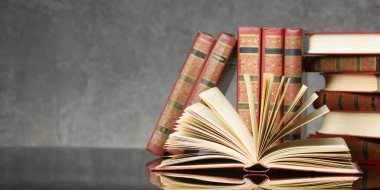 Açık kitap, ahşap masadaki ciltli kitaplar. Okula dönelim. Boşluğu kopyala.