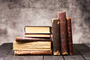 Eski kırsal ahşap yüzeyde eski deri kitaplar yığılıyor.