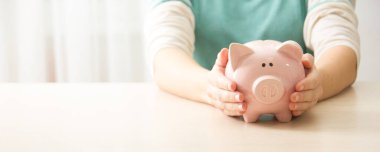 Kadın, para biriktirmek ve finansal konsept için domuzcuğa para yatırıyor.