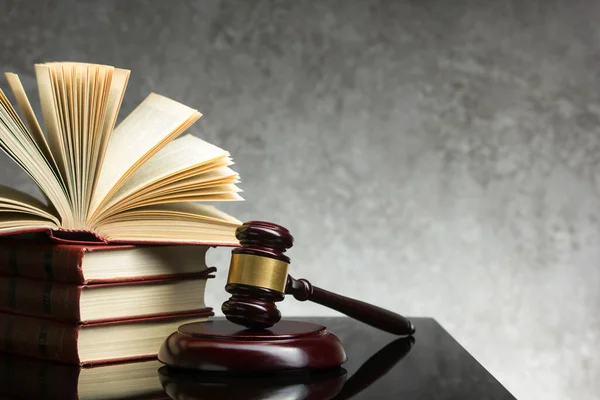 法律和司法概念- -带木制法官的开放式法律书籍，放在法庭或执法办公室的桌上。文本的复制空间. — 图库照片