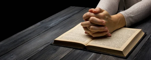 暗い部屋の聖書の本の祈りの手 — ストック写真