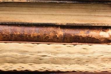 Eski kırsal ahşap yüzeyde eski deri kitaplar yığılıyor..