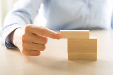 İş dünyasında plan ve strateji, İş Büyütme Riski Ahşap bloklar ile İş Büyüme Konsepti, insan eli yığılır ve ahşap bir blok istifleme