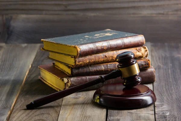 Legal Law and Justice concept - Open law book with a wooden judges gavel on table in a courtroom or law enforcement office. Copy space for text