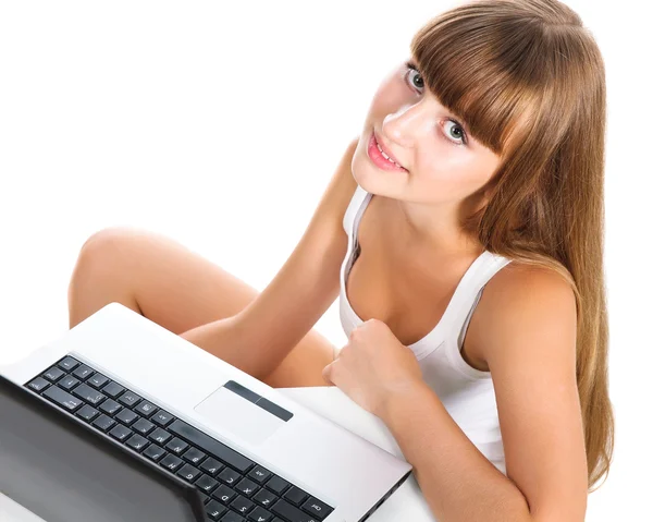 Cute teen girl sitting with laptop isolated over white — Stock Photo, Image