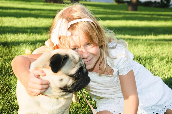 Linda chica abrazándose con un perro encantador en el parque en el día de verano —  Fotos de Stock