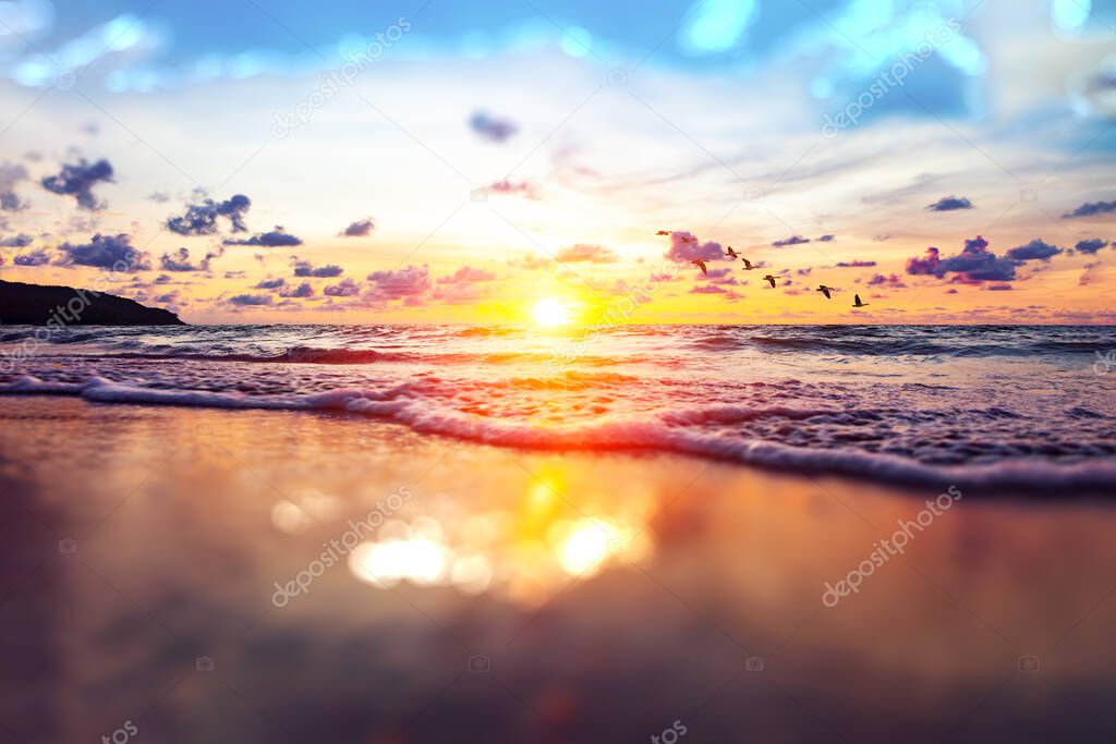 Beautiful cloudy landscape over the sea. Beach sand and sunset on the shore.