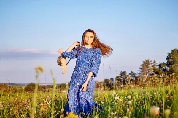 穿着蓝色衣服的女孩在田野里散步 — 图库照片