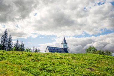 Kırsal bir yerde küçük bir kilise Bulutlu bir havada yeşil bir çayırda