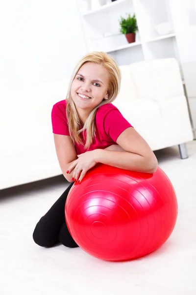 Menina e bola de fitness vermelho — Fotografia de Stock