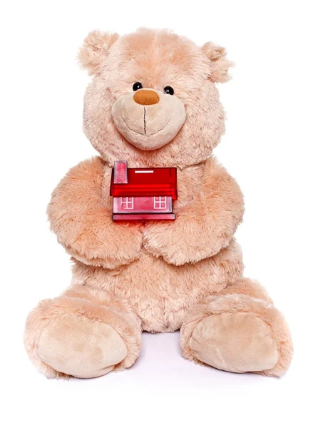 Teddy bear holding miniature house — Stock Photo, Image