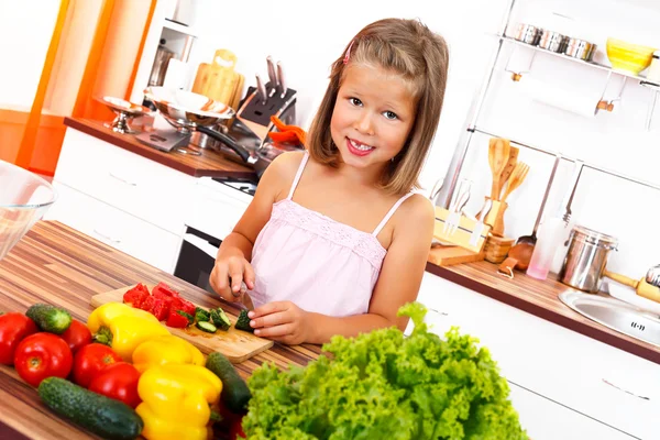 Kleines Mädchen schneidet Gemüse — Stockfoto