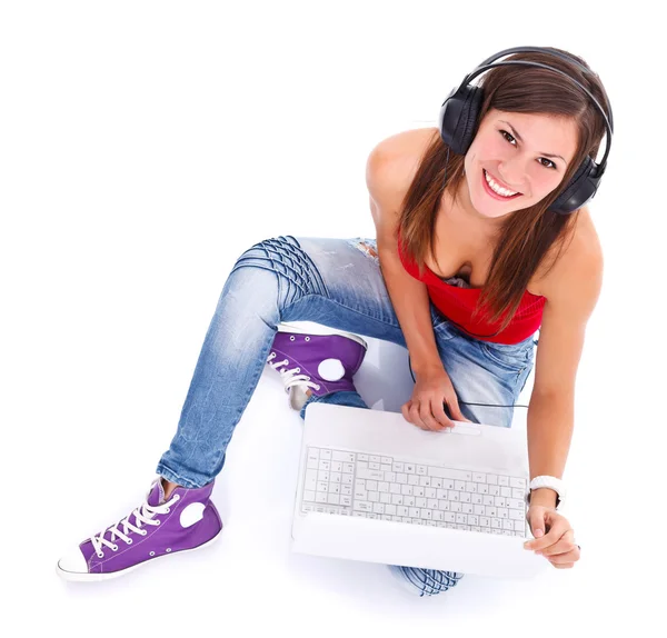 Mulher sorridente com fones de ouvido e laptop — Fotografia de Stock