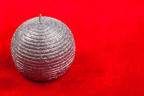 Silver candle over red background