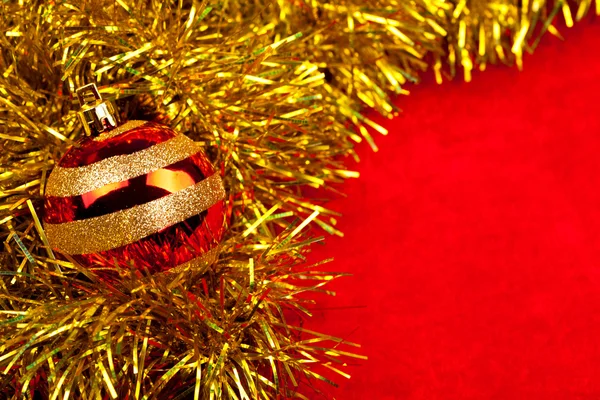 Christmas globe on golden tinsel — Stock Photo, Image