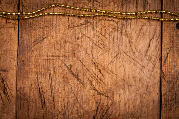 Wooden background with golden pearls — Stock Photo, Image