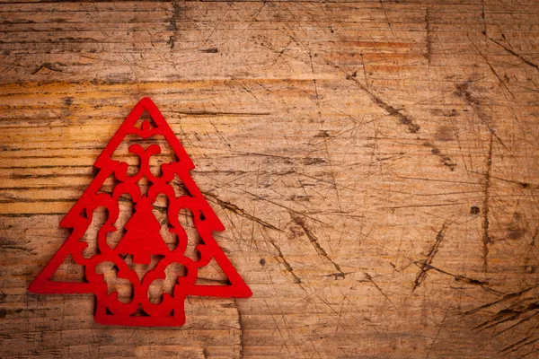 Pequeno ornamento de Natal vermelho no fundo de madeira — Fotografia de Stock