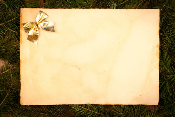 Gold bow on aged paper sheet — Stock Photo, Image