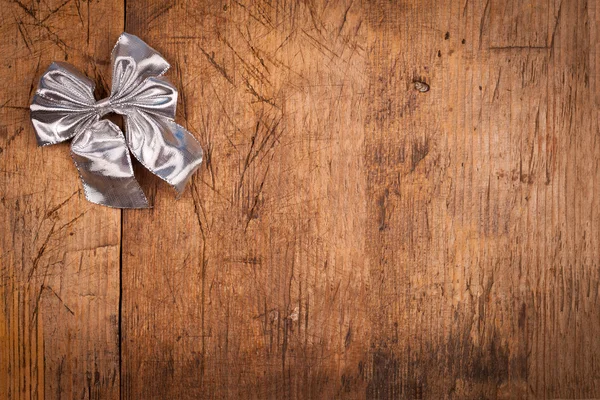 Small silver ribbon on wooden background — Stock Photo, Image