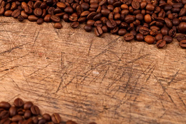 Alter Holztisch mit Kaffeebohnen — Stockfoto
