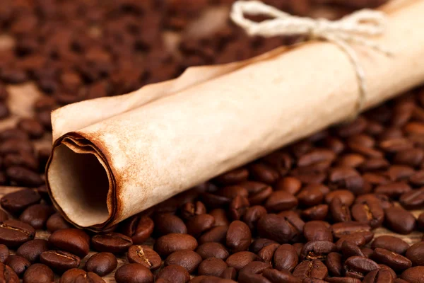 Vista de primer plano del rollo de papel rústico y granos de café — Foto de Stock