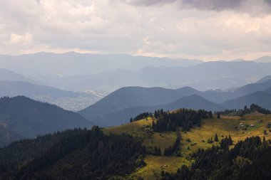 Ukrayna Karpatları 'nın dağ yamaçlarında. Dağın tepeleri ve ormanlar mavi gökyüzünün arka planında.