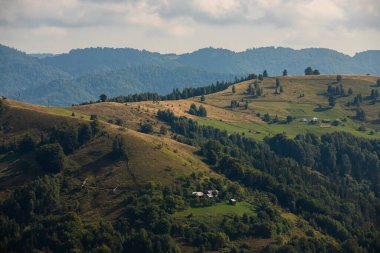 Ukrayna Karpatları 'nın dağ yamaçlarında. Dağın tepeleri ve ormanlar mavi gökyüzünün arka planında.