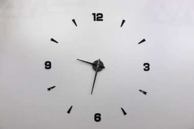 Siyah sayılı duvar saatinin minimalist tasarımı.