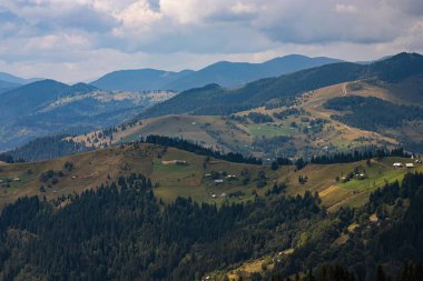 Ukrayna Karpatları 'nın dağ yamaçlarında. Dağın tepeleri ve ormanlar mavi gökyüzünün arka planında.