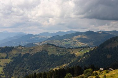 Ukrayna Karpatları 'nın dağ yamaçlarında. Dağın tepeleri ve ormanlar mavi gökyüzünün arka planında.