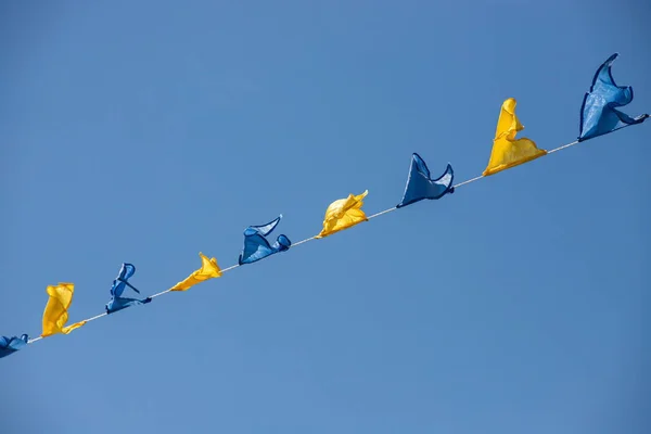 Żółte Niebieskie Trójkątne Flagi Festiwalowe Tle Nieba Białymi Chmurami Impreza — Zdjęcie stockowe