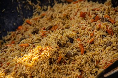 Açık havada büyük bir kazanda sıcak pilav. Geleneksel doğu yemekleri. Sokak yemekleri konsepti. Yakın çekim.