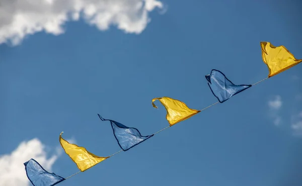 Żółte Niebieskie Trójkątne Flagi Festiwalowe Tle Nieba Białymi Chmurami Impreza — Zdjęcie stockowe