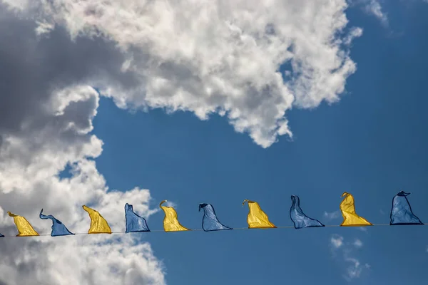 Жовтий Синій Трикутні Прапори Фестивалю Тлі Неба Білими Хмарами Вечірка — стокове фото