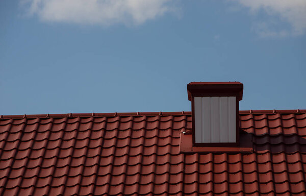 chimney on the roof of the house against the blue sky.