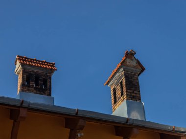 Seramik kiremit çatı baca ve beyaz duvar, mavi gökyüzü arka plan olarak.