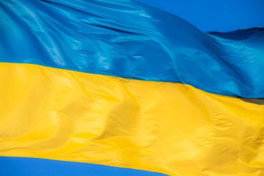 Rüzgarda savrulan Ukrayna bayrağı. Gökyüzünün arka planına karşı.